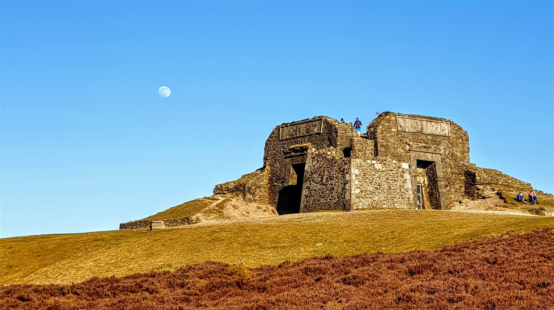 The Jubilee Tower ruins on the summit of Moel Famau with the moon in a blue sky